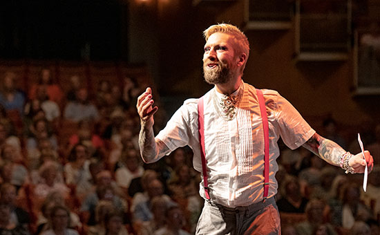 Rickard Söderberg, allsångsledare på stora scenen med publikhav i bakgrunden