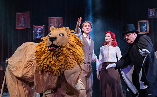 Ett lejon och några sångare i föreställningen "Inget får hejda premiären"