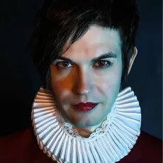 Porträtt på Timur Bekbosunov klädd i svart, med vit pipkrage