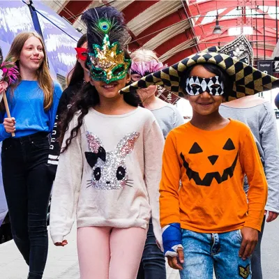 Barn i masker går på en tågperrong