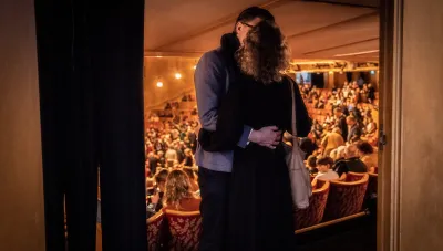 Ett par kysser varandra i salongen