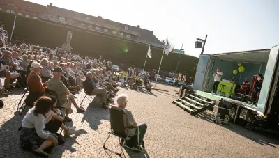 Publik tittar på föreställning på ett lastbilsflak