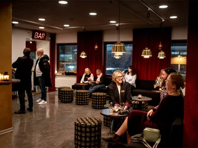 Människor sitter utspridda i Operaverkstans foajé
