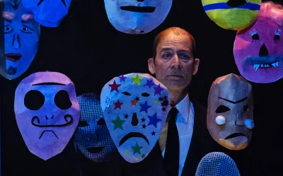 En mans ansikte och flera masker runt om