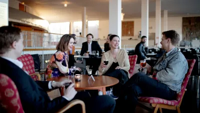 Gäster sitter vid ett bord i foajén